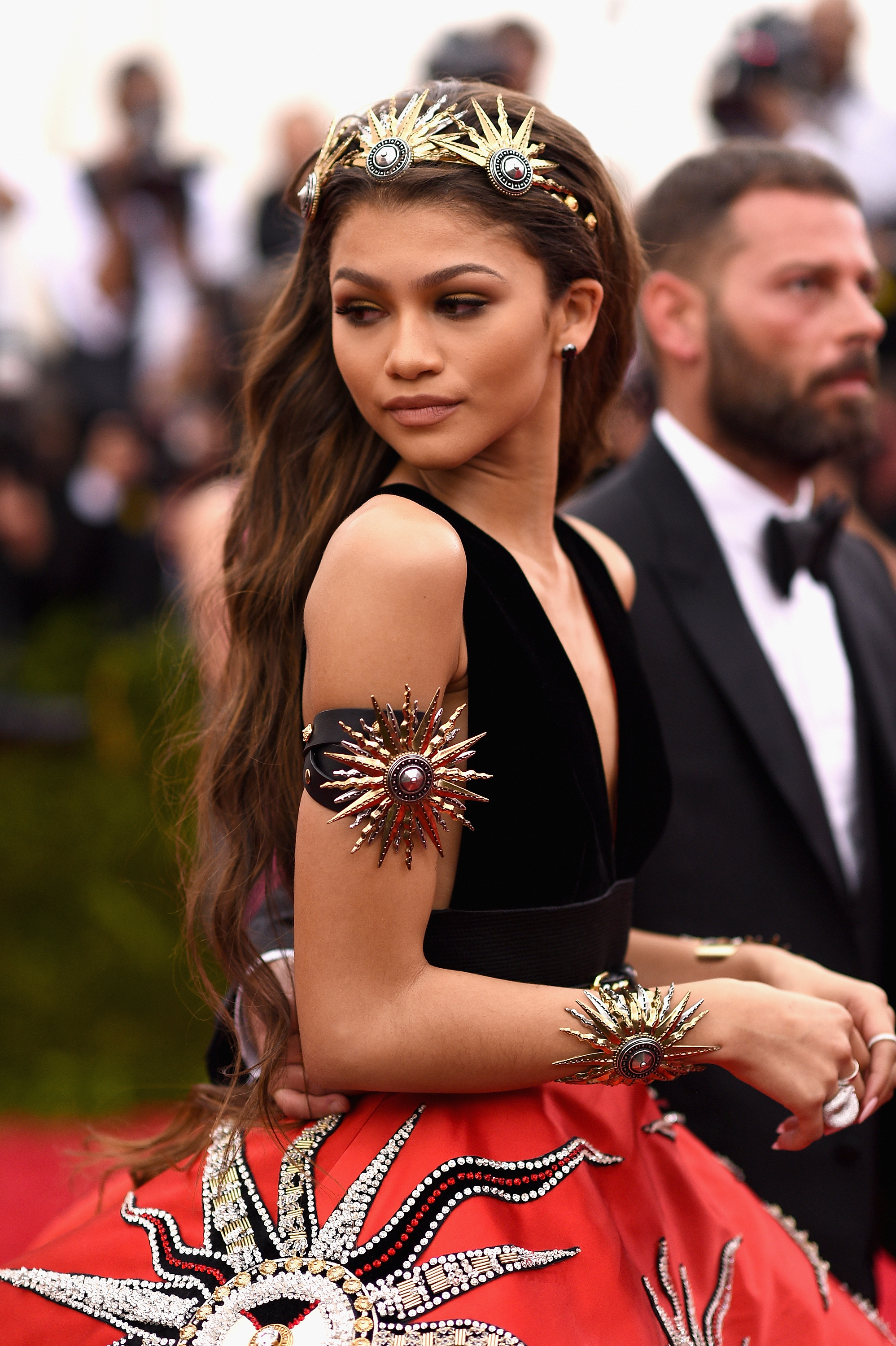 Zendaya in a black dress with embellished accents and a headpiece at a gala event