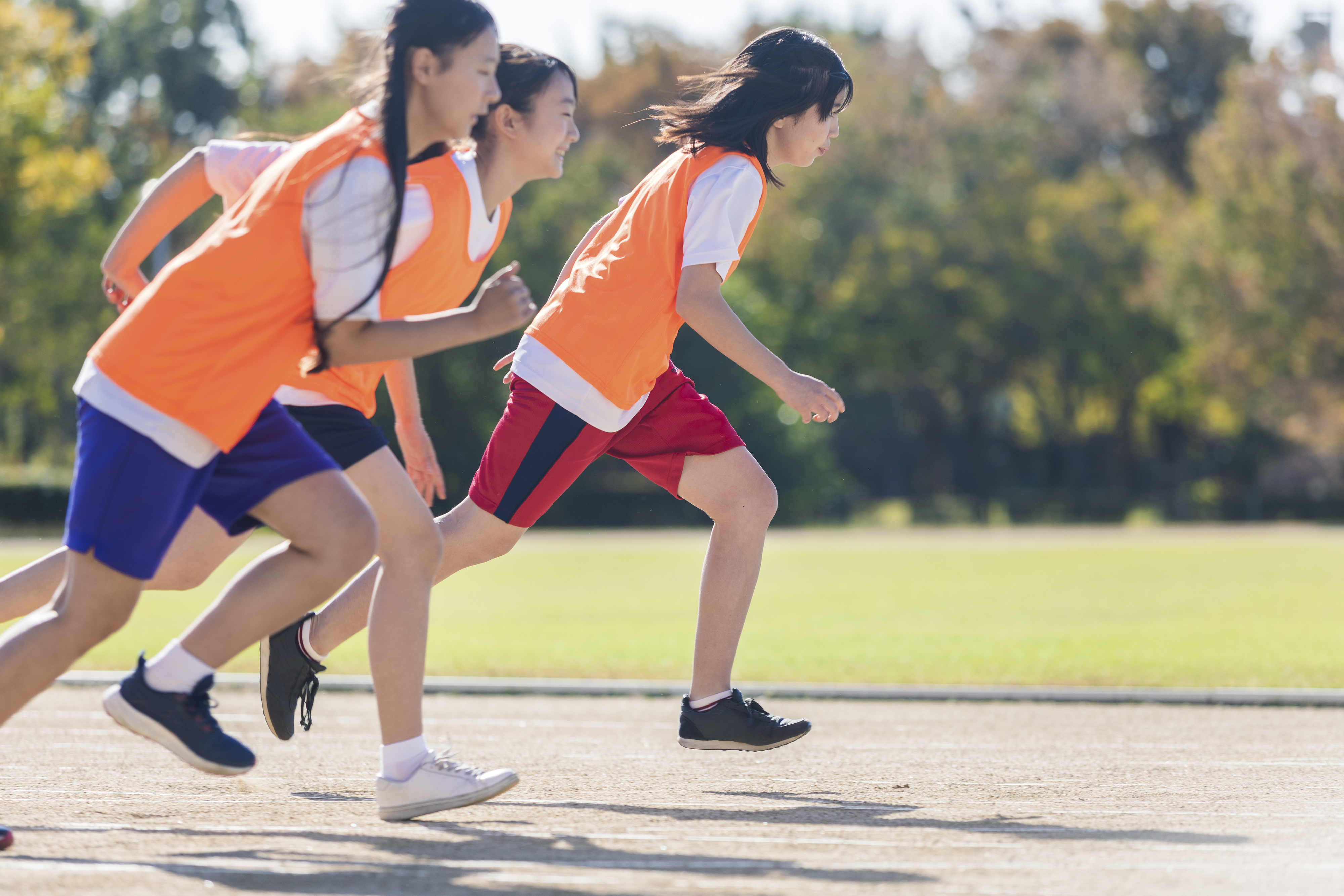 Children in sportswear running in a relay race, exemplifying active travel experiences