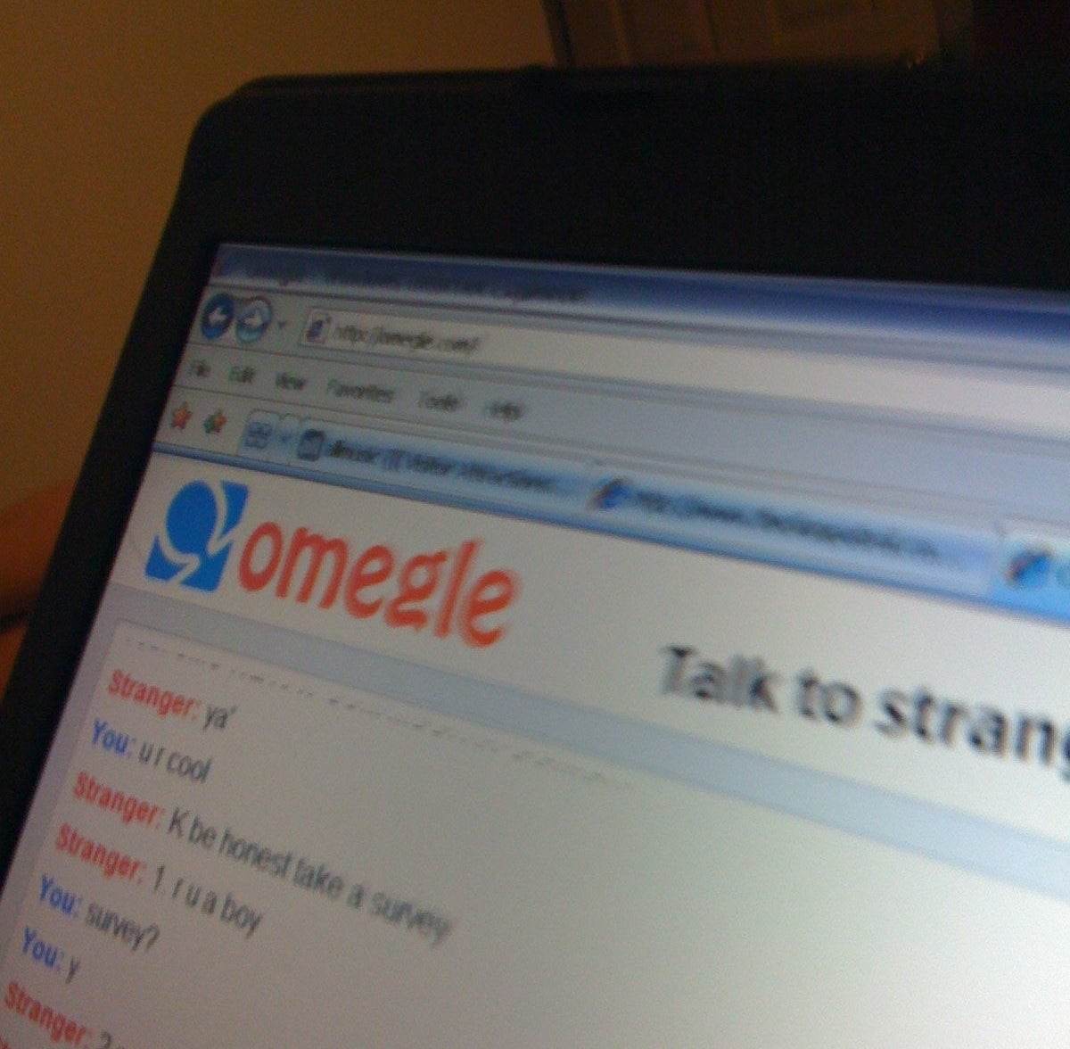 Omegle chat on a screen with text &quot;Talk to strangers&quot; and a conversation in progress