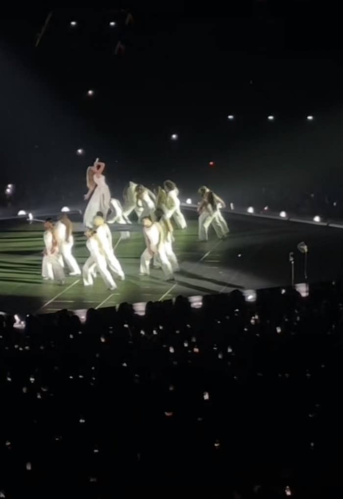 Taylor floats above a circle of dancers onstage