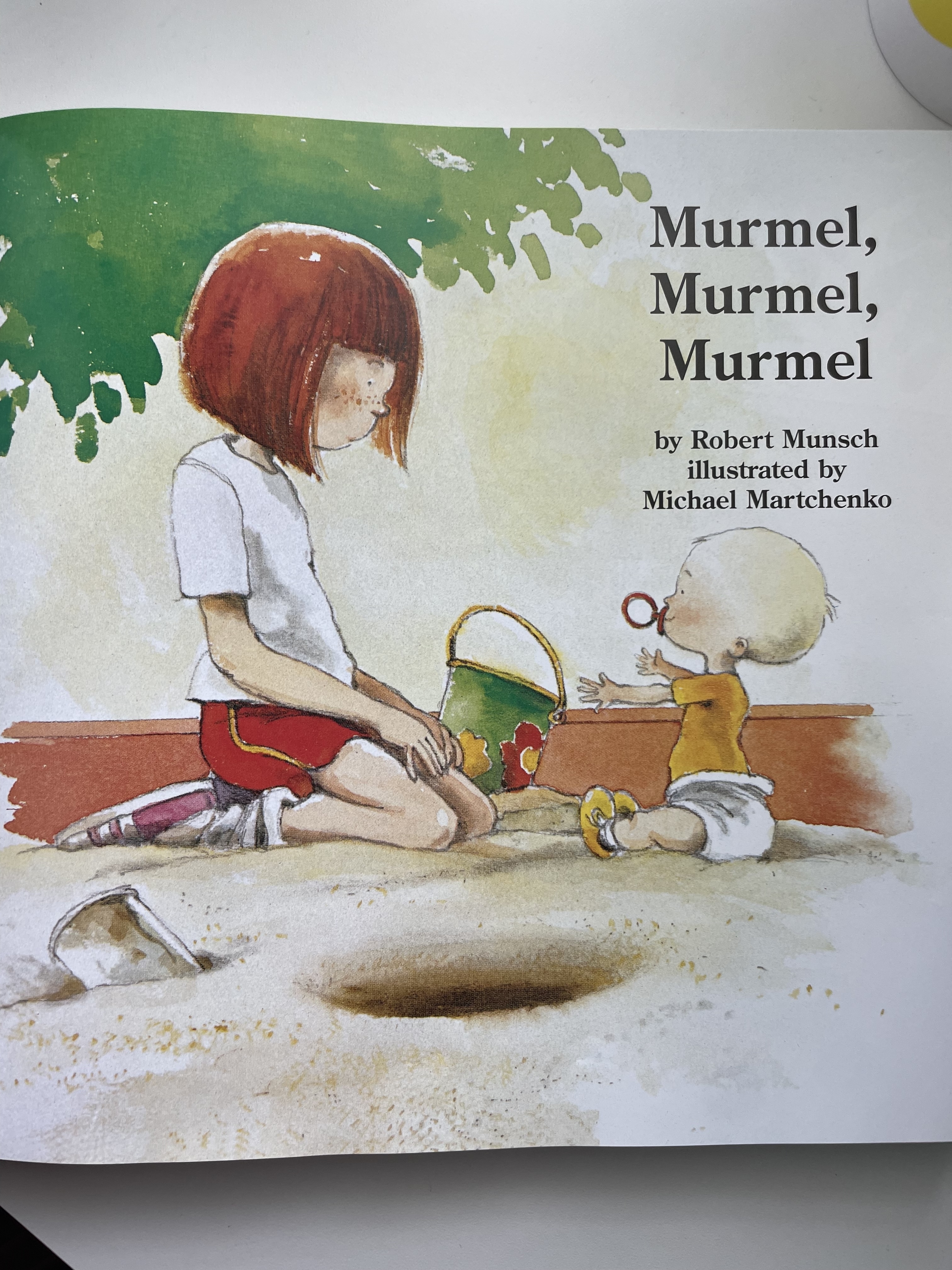 Illustration from &quot;Murmel, Murmel&quot; showing a girl sitting on the ground next to a baby who is holding a sand pail