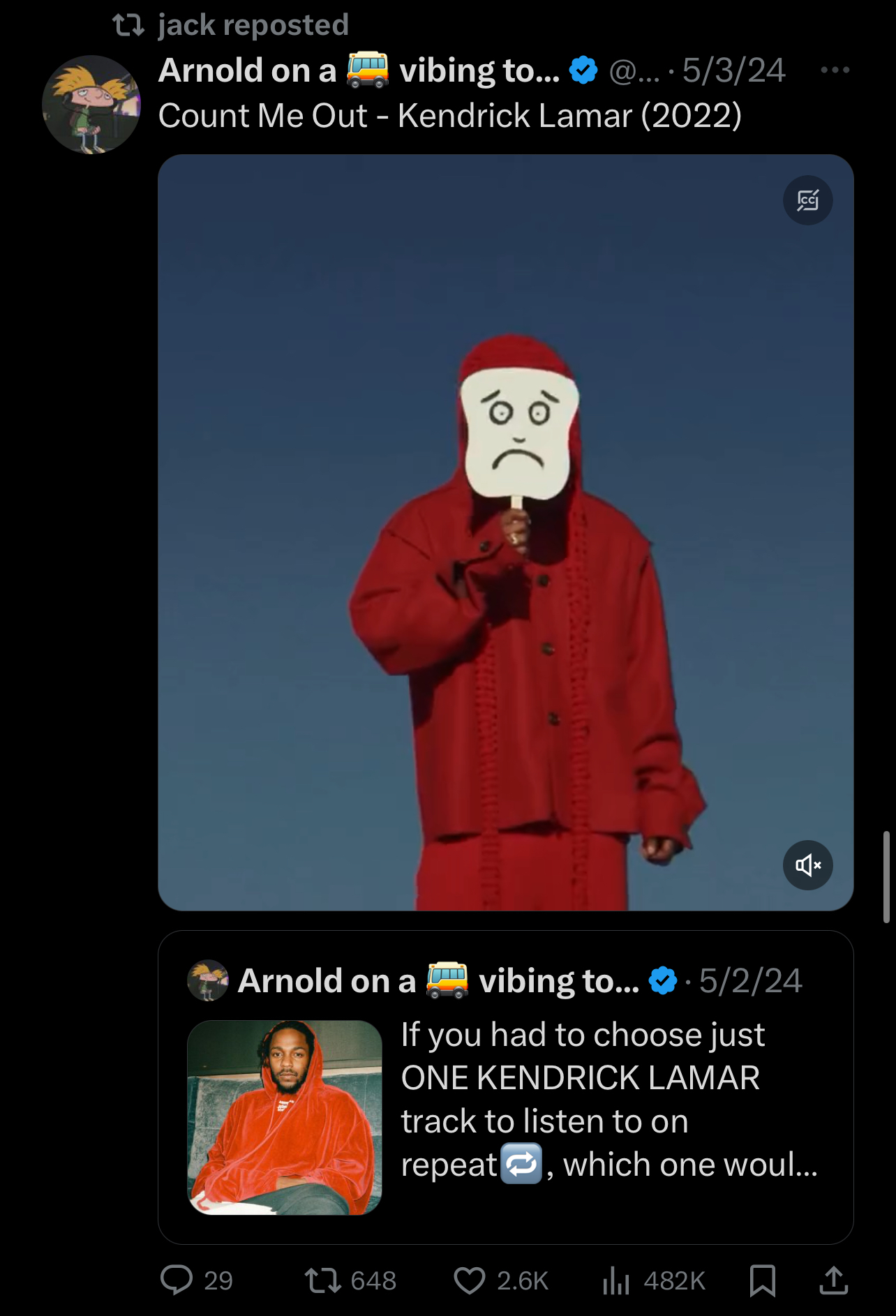 Person in red hooded outfit with a placard face onstage, with reposted tweet overlay