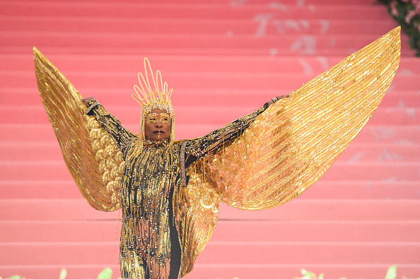 Person in ornate golden costume with wingspread at an event