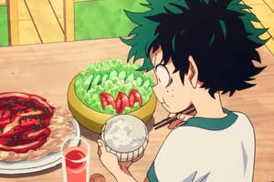 Izuku Midoriya, an animated character, looks amazed at a table with dishes, holding a rice bowl
