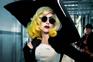 Lady Gaga wearing a large hat, elegant clothing, and round sunglasses while rocking dyed hair in the telephone music video
