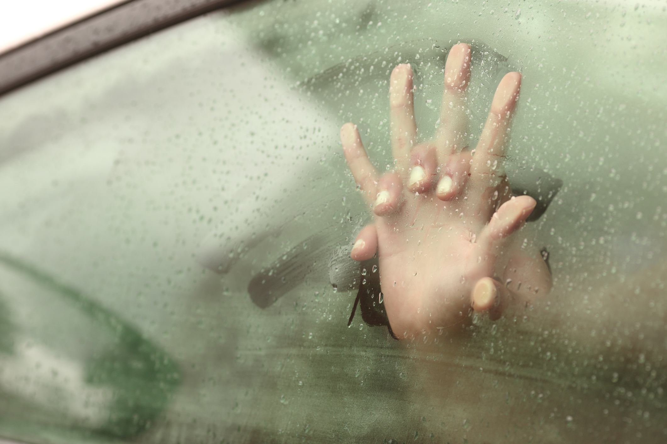 Hand pressed against steamy car window, implying intimacy