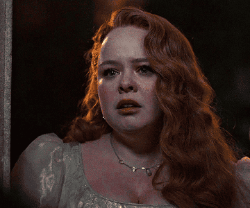 Personaje de la película interpretado por una actriz, expresión preocupada, vestido con detalles de época