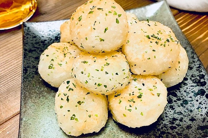 皿の上に並べられた丸いパンにパセリがかけられている。