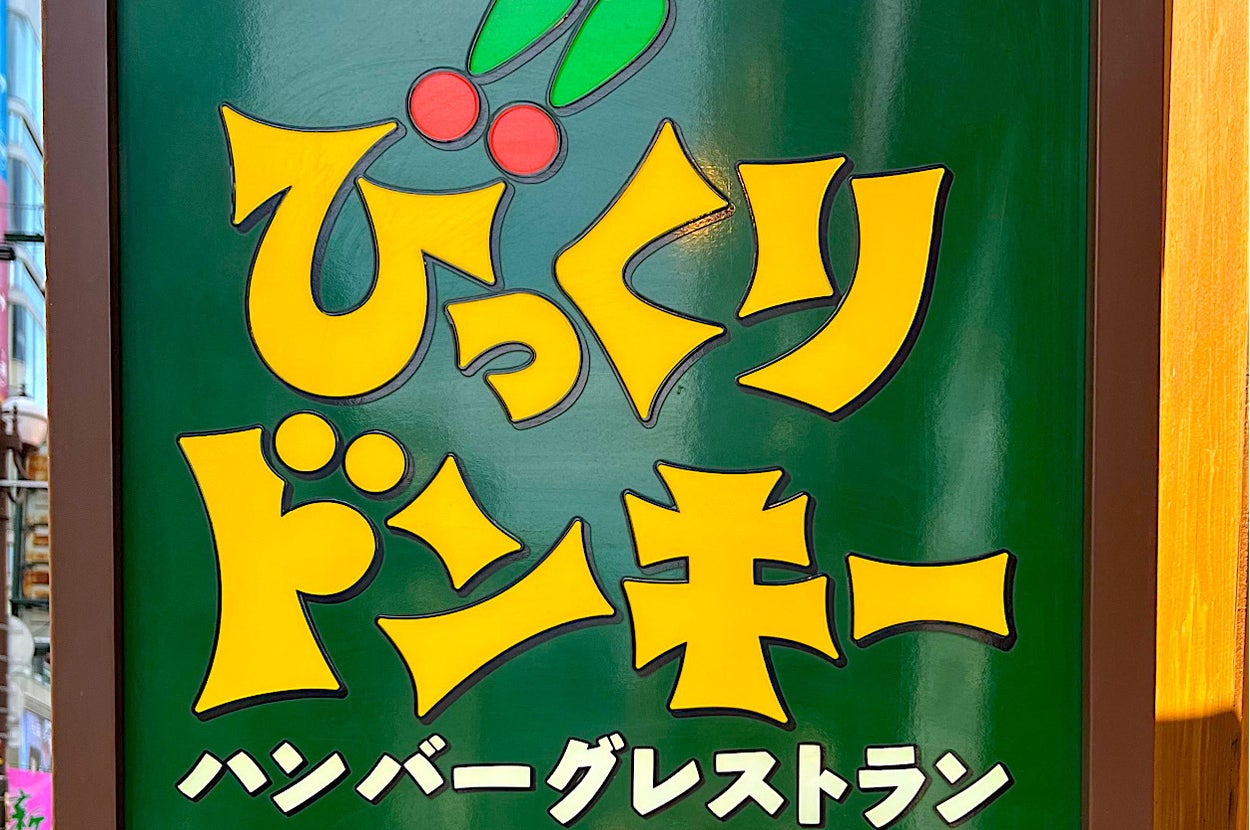 Signboard with Japanese characters and playful font advertising possibly a shop or game center