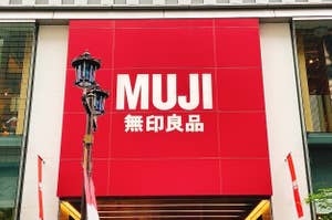 A large MUJI store sign with logo and Japanese characters