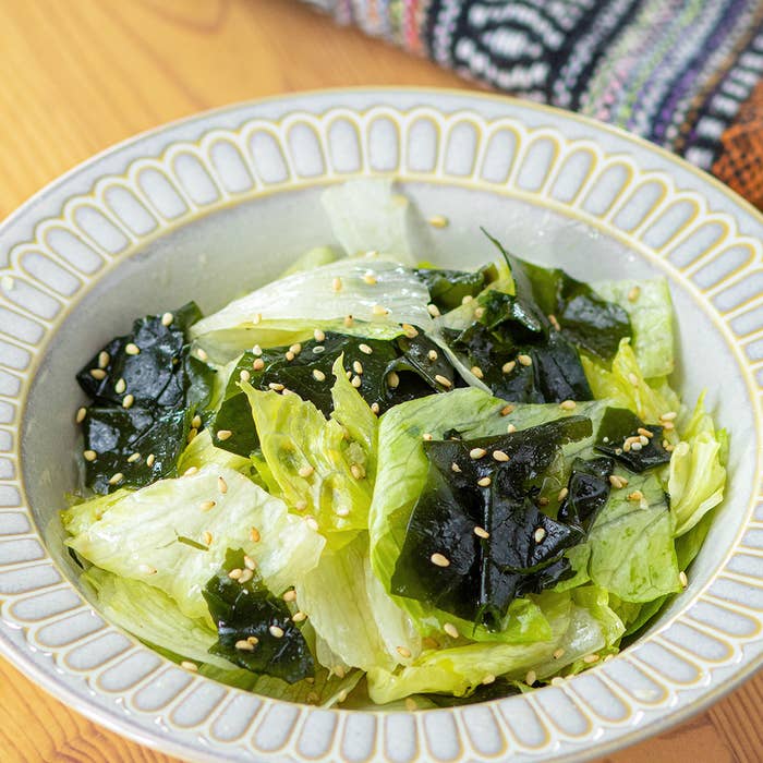 わかめとレタスのサラダが盛りつけられた皿がテーブルに置かれています。