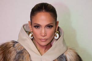 Jennifer Lopez in a fur-trimmed coat and large hoop earrings