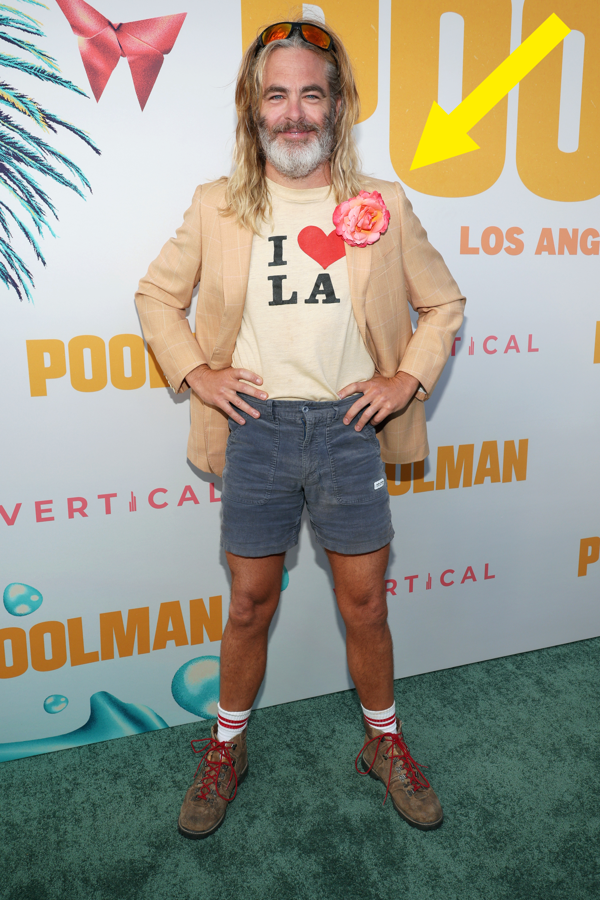 Chris Pine in beige jacket, &quot;I ❤️ LA&quot; shirt, denim shorts, with flower accessory at movie premiere