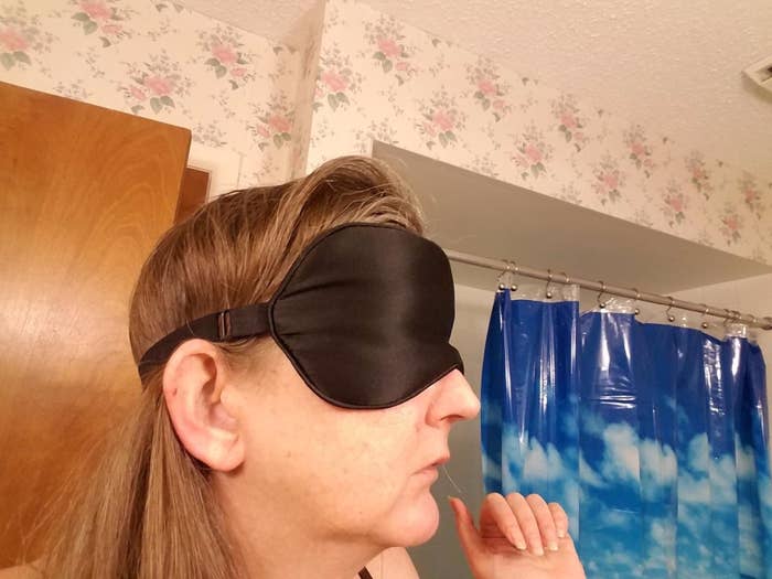 Reviewer wearing the sleep mask, adjustable headband visible from side