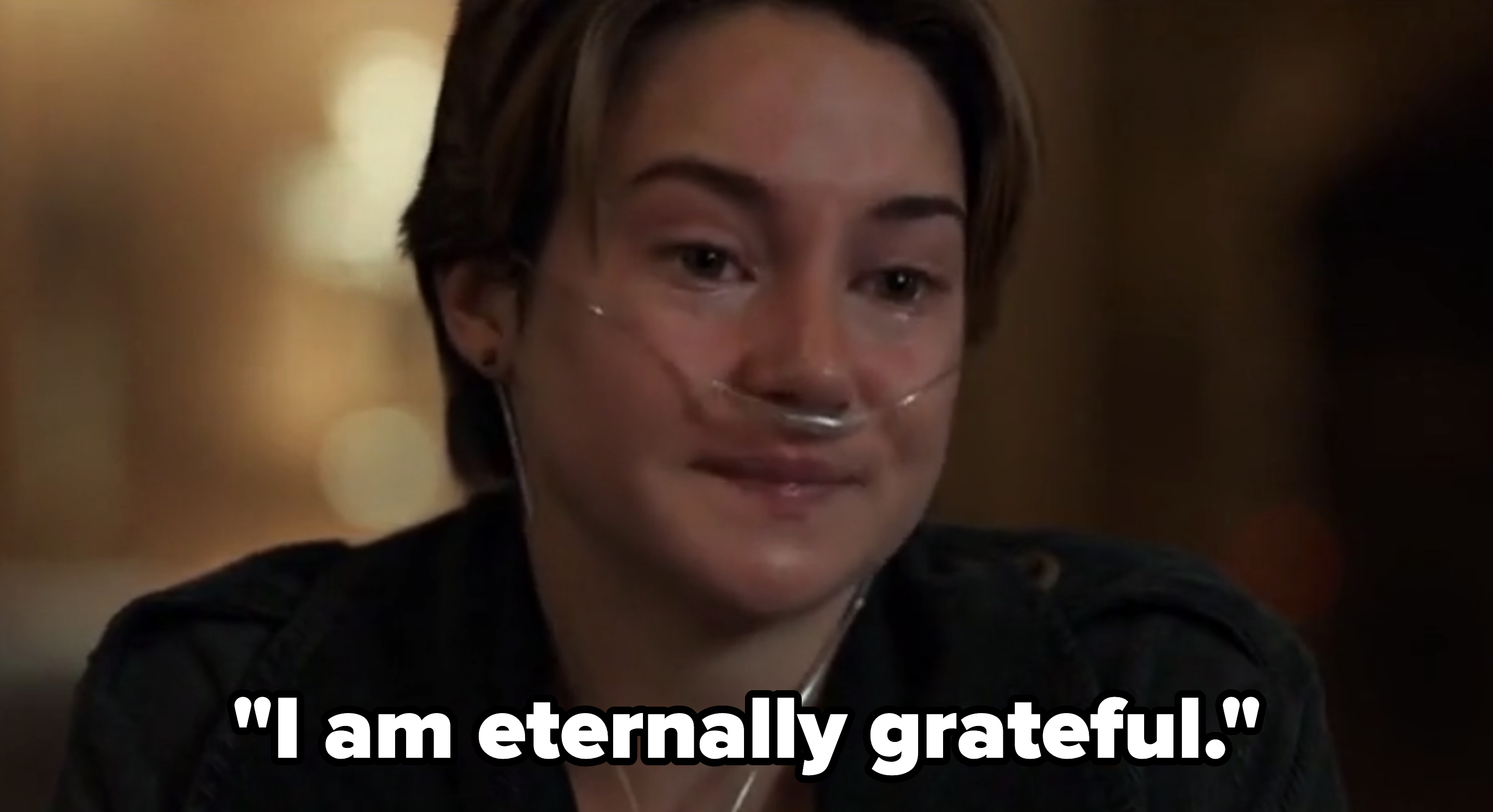 Person with a nasal cannula, looking emotional in a dimly lit room