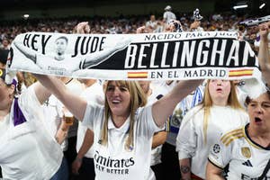 Fans holding a banner supporting Jude Bellingham, with text and his illustration