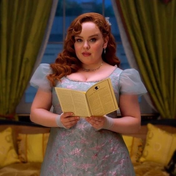 Personaje de ficción con vestido estampado sujetando un libro abierto