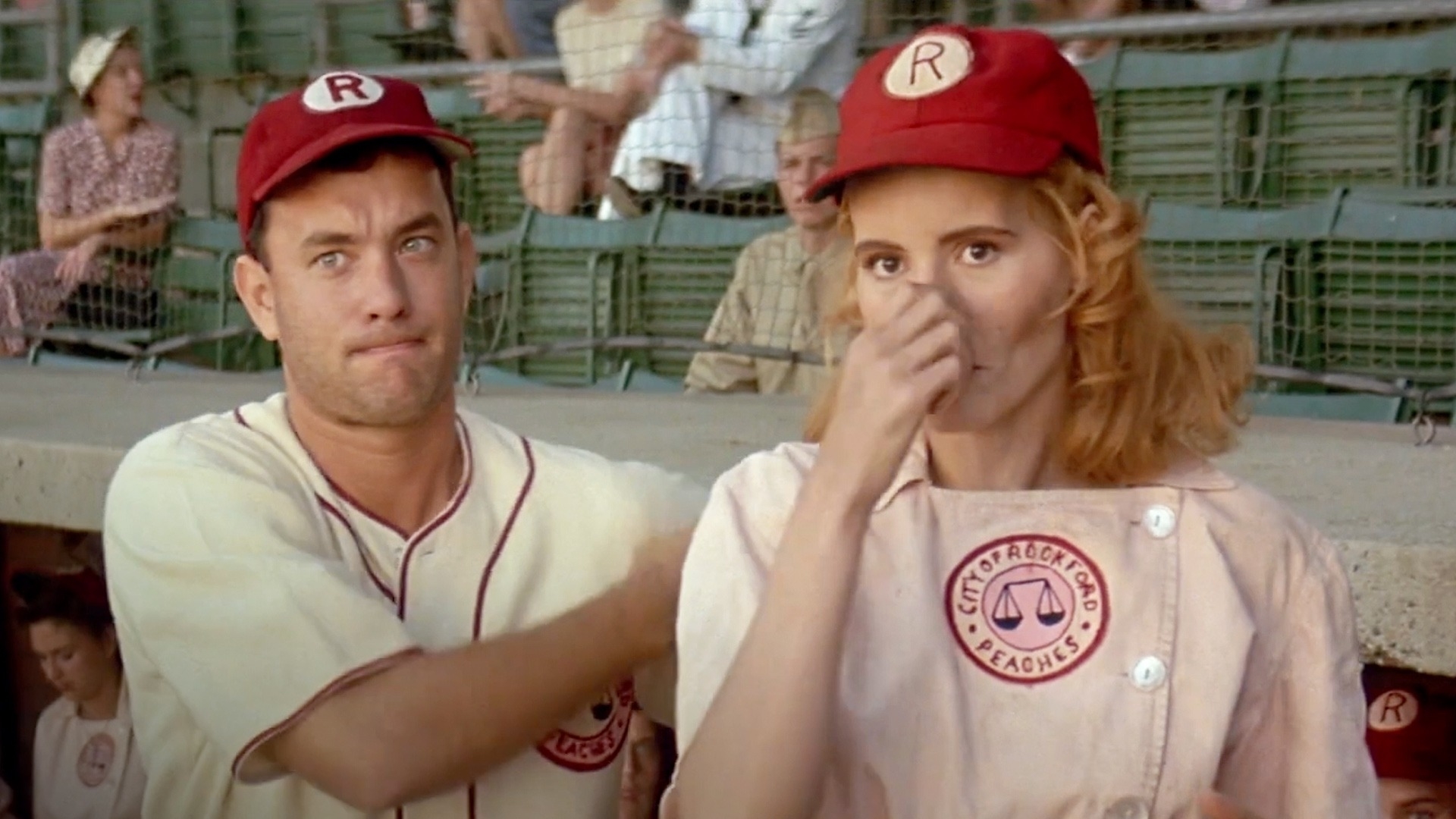 Tom Hanks and Geena Davis in a baseball uniform, looking surprised, in the film &#x27;A League of Their Own&#x27;