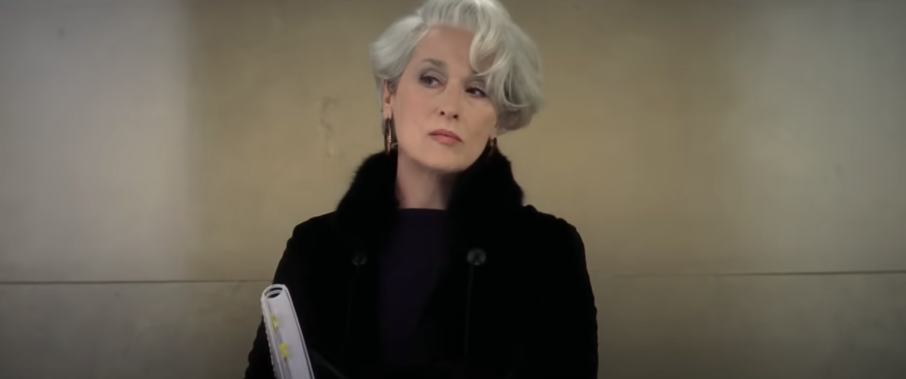 Miranda Priestly, portrayed by Meryl Streep in 'The Devil Wears Prada', is shown looking stern with a fur-trimmed coat