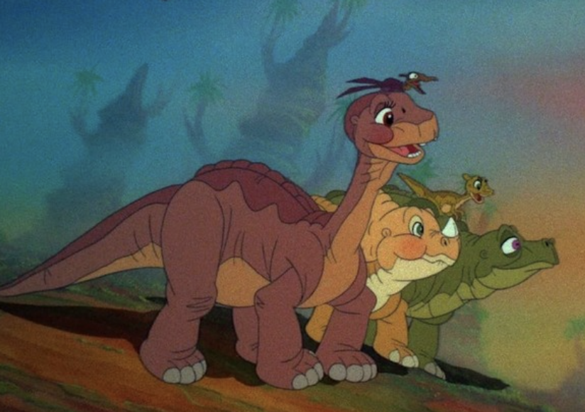 Animated characters Littlefoot, Cera, Ducky, Petrie, and Spike from &quot;The Land Before Time&quot; walking in a line