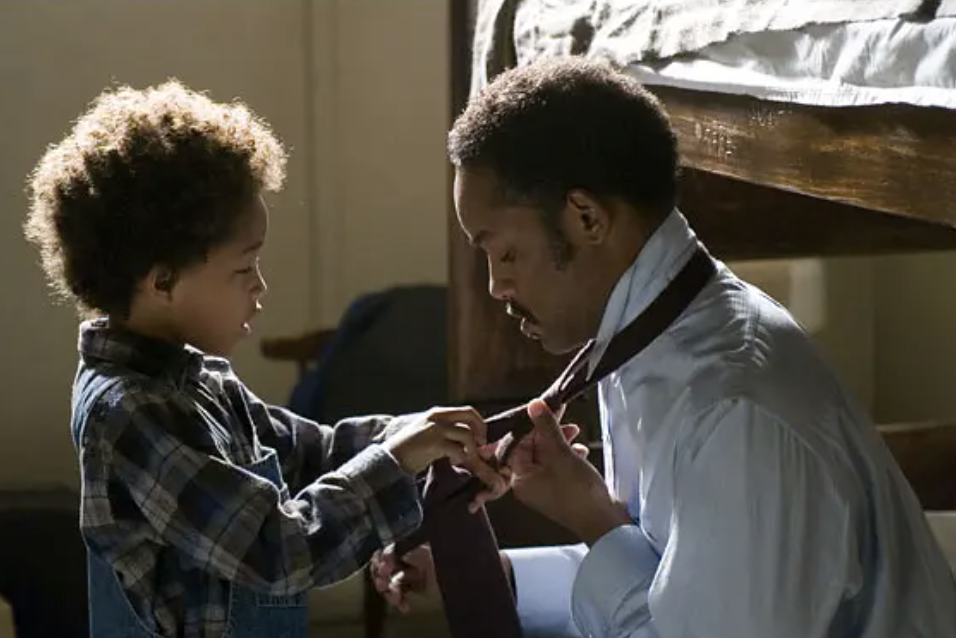 Child helps a man, possibly his father, with his tie in a tender moment