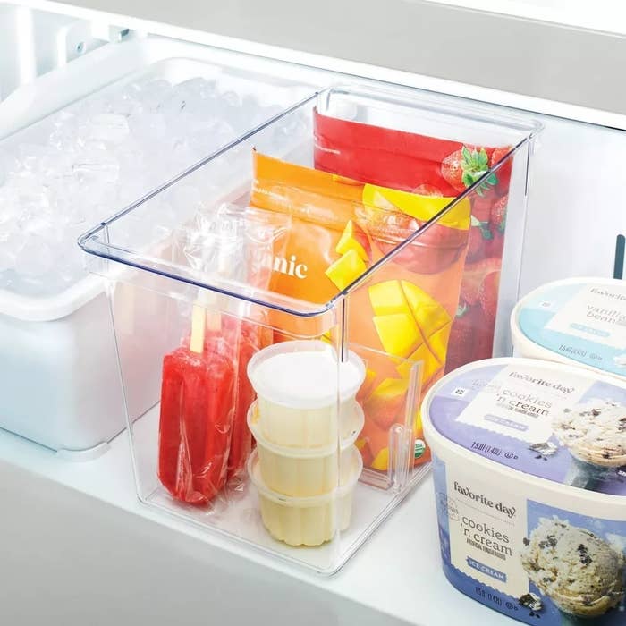 Clear fridge storage bin with various packaged foods