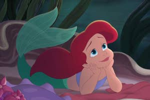Ariel from The Little Mermaid is lying down with her chin on her hands, looking dreamy