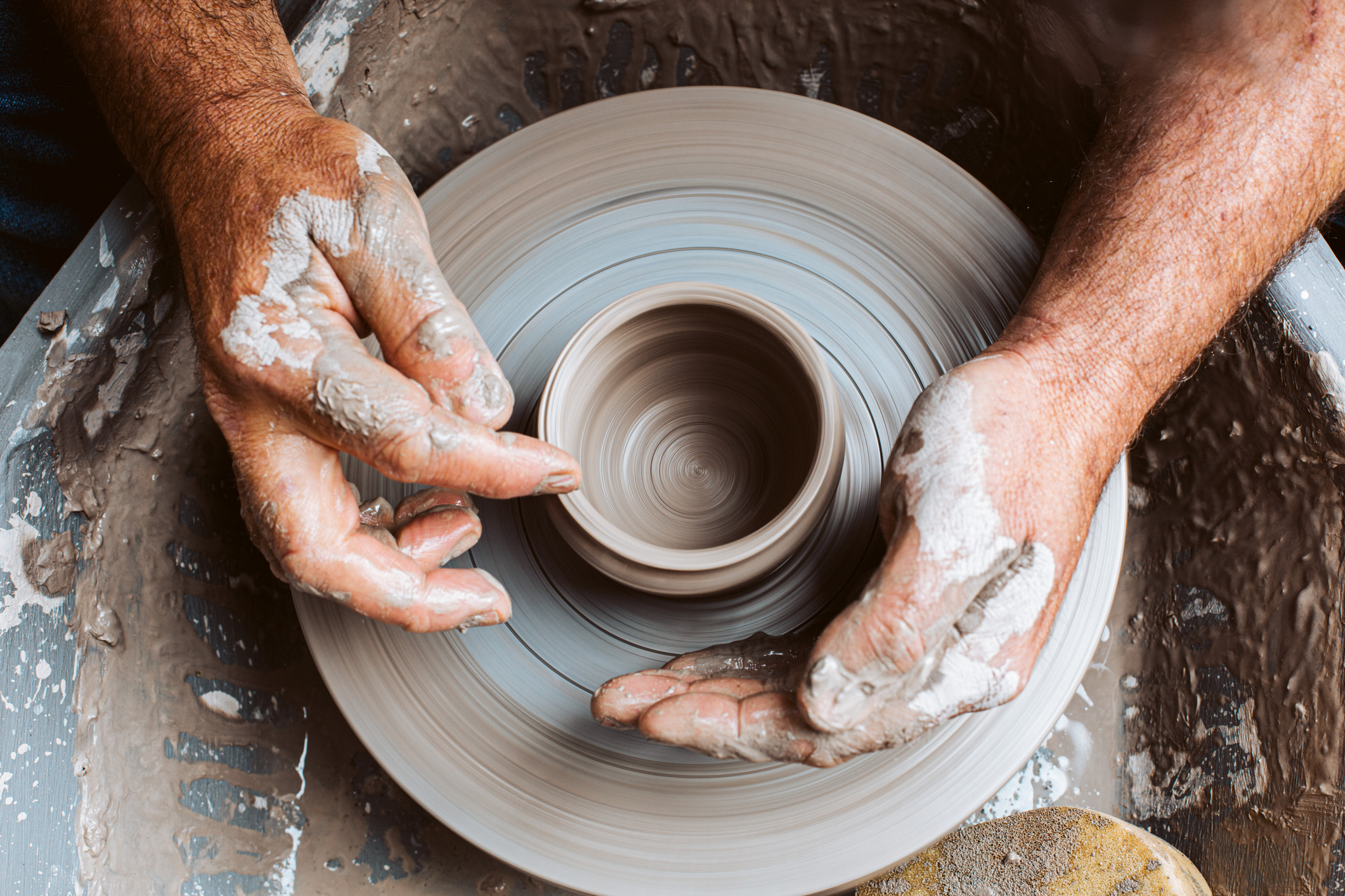 Close-up of hands shaping clay on a pottery wheel