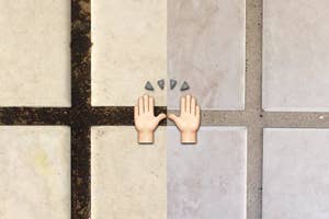 A tiled floor with an emoji of two hands clapping centered between the tiles