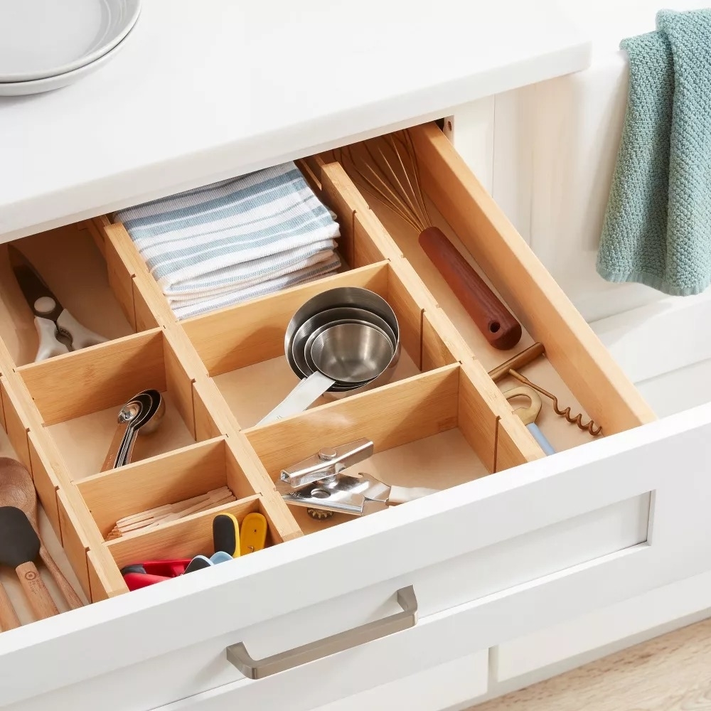 Organized kitchen drawer with dividers holding utensils and gadgets