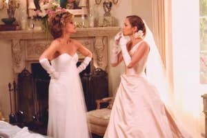 Two women in elegant strapless gowns face each other with expressions of surprise or confrontation