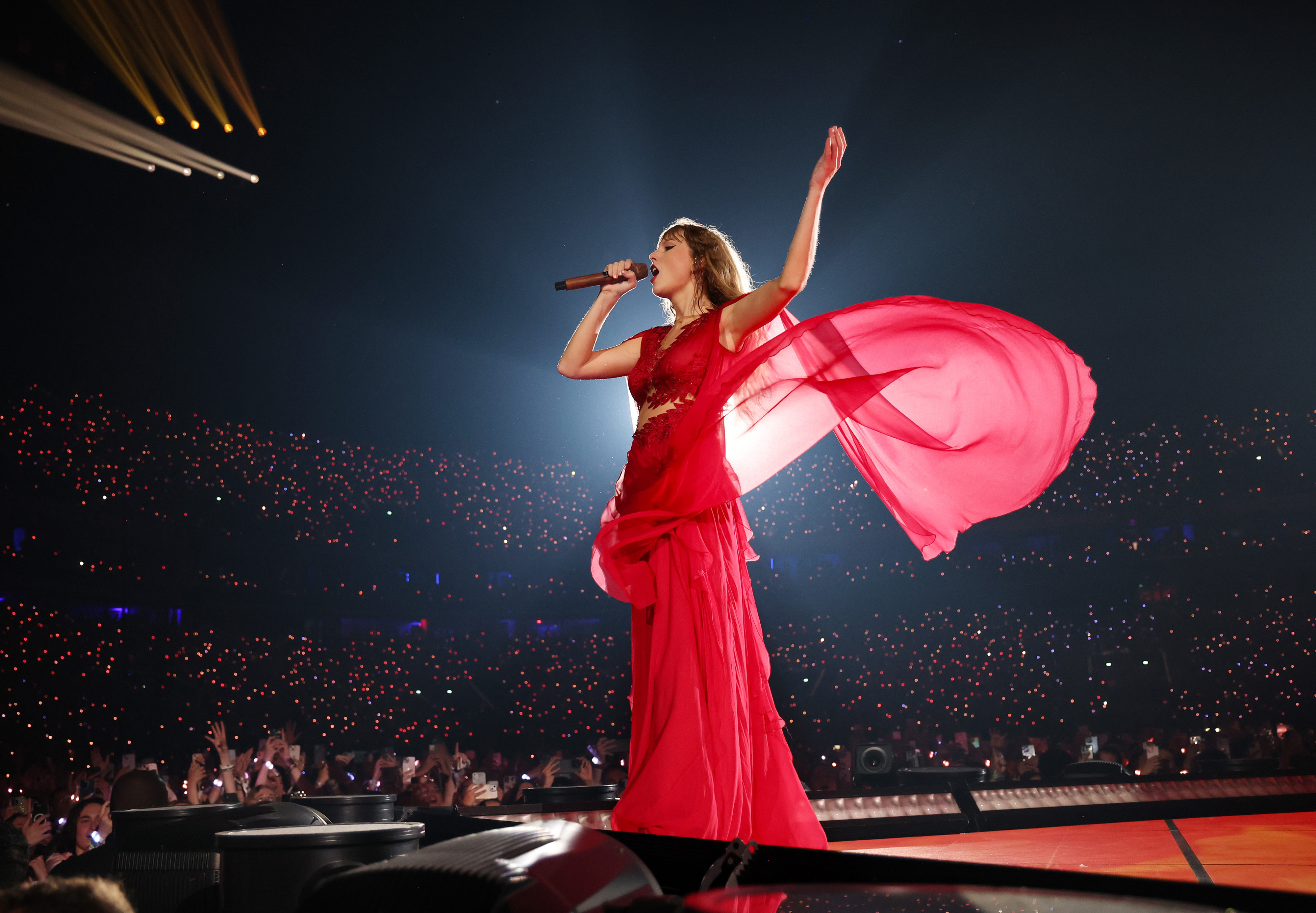 Taylor Swift in flowy dress performing on stage
