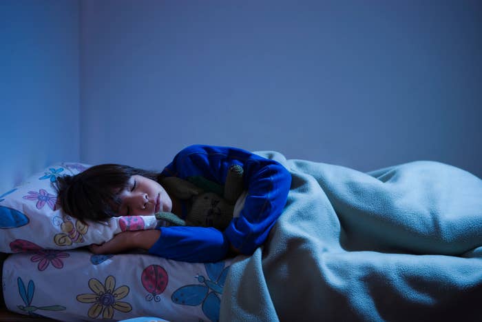 Child sleeping peacefully with a stuffed toy