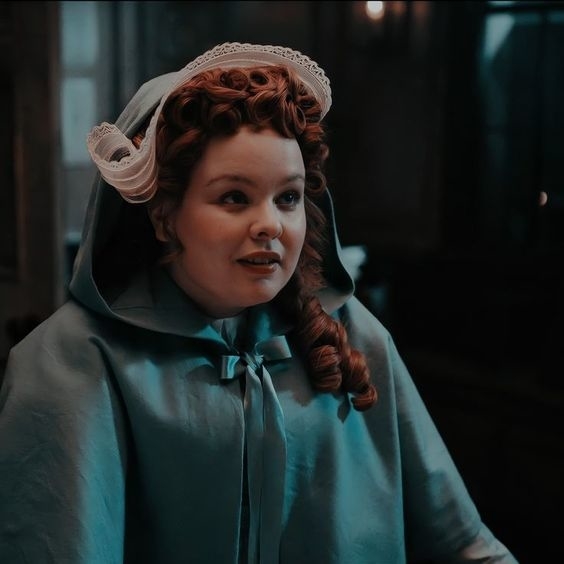 Personaje de &quot;Bridgerton&quot; con capa y cofia estilo regencia