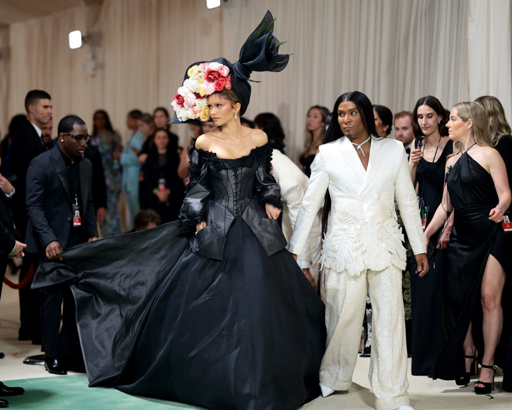 Zendaya and Law on the Met Gala red carpet,  in a vintage style gown with floral headpiece and him in a light suit with feathery details