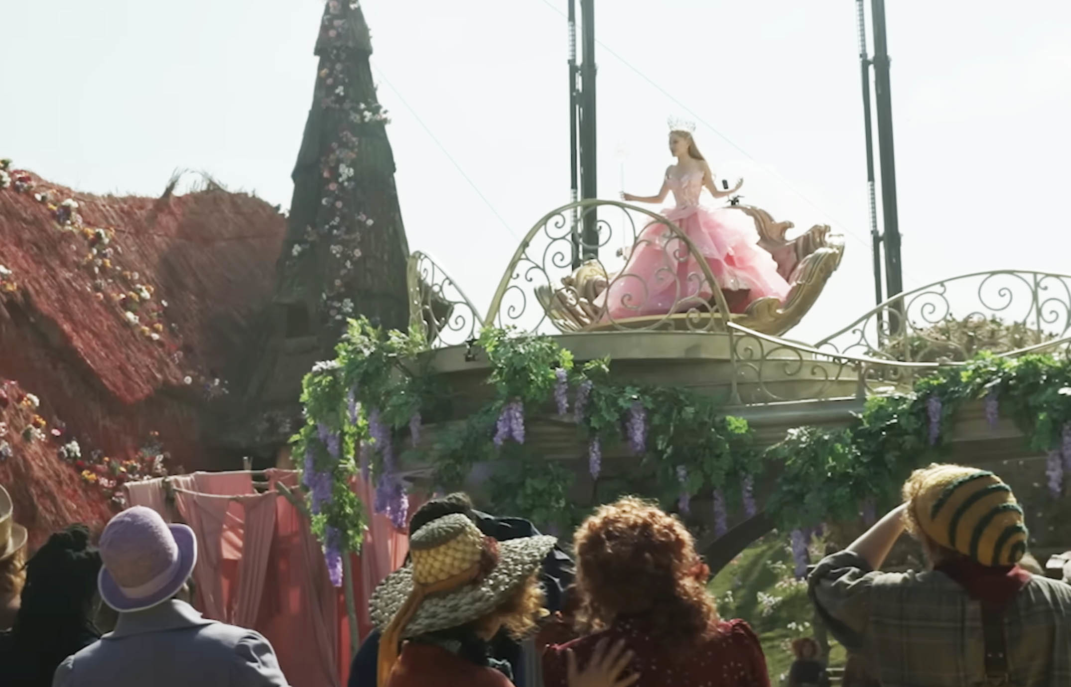 Glinda on a roof above the citizens of Oz