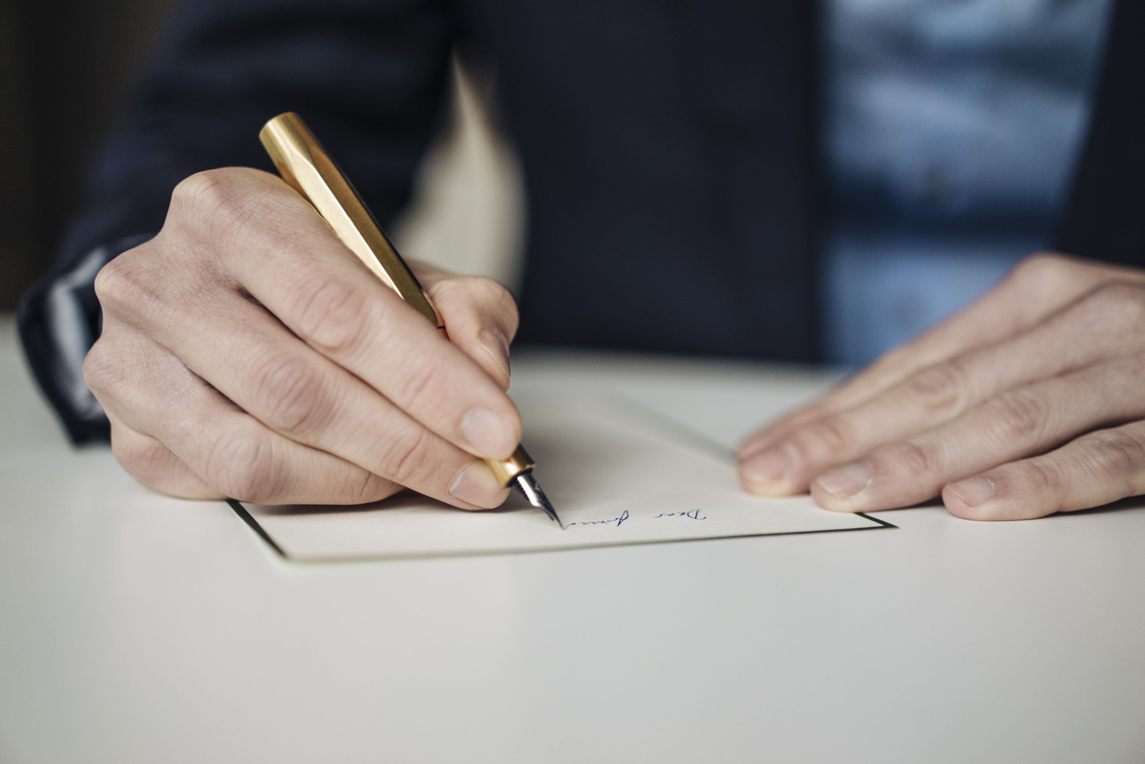 Person signing a document, focused on hands and pen, implying a professional agreement or contract