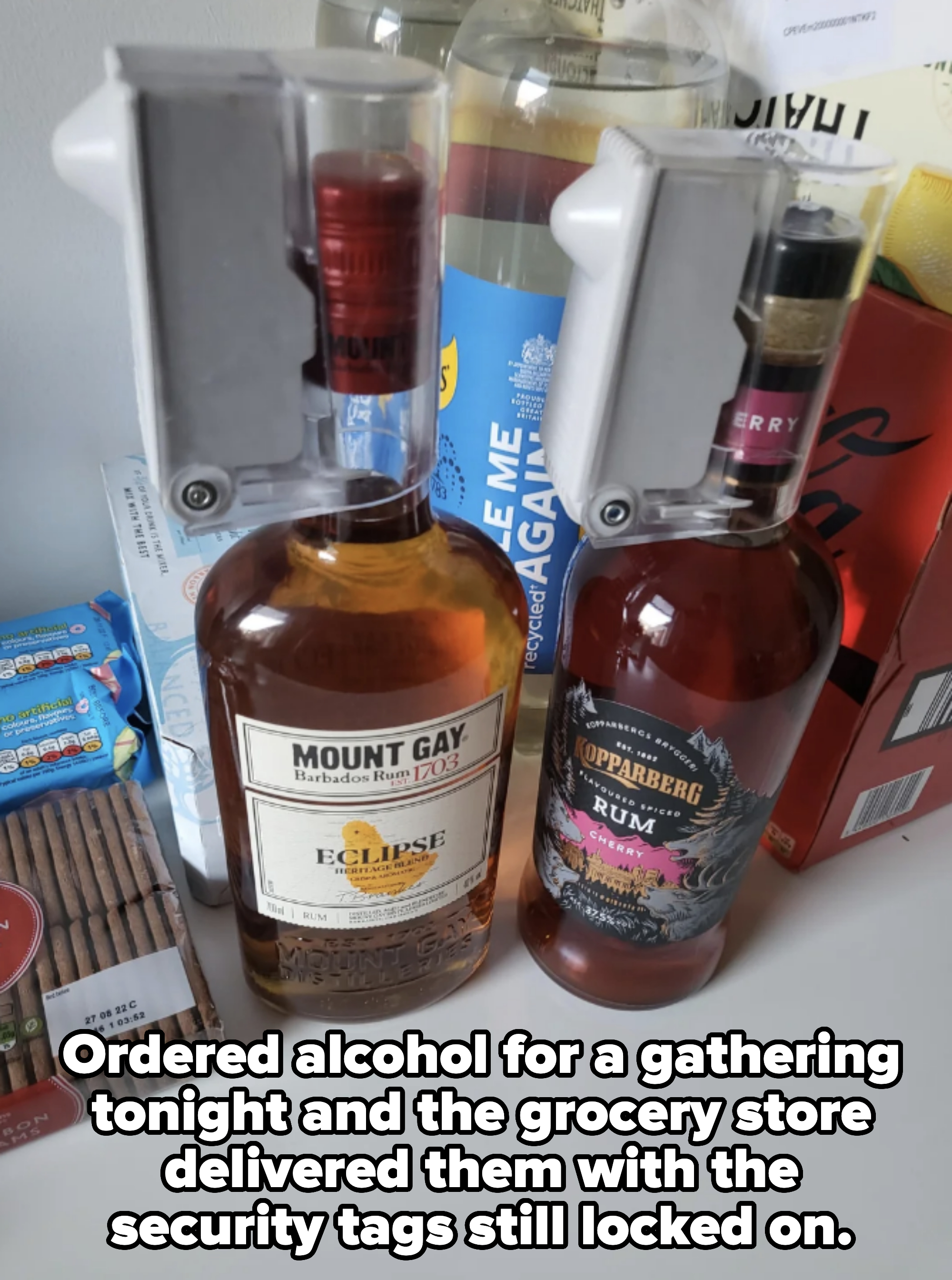 Two bottles of rum, Mount Gay Eclipse and Kopparberg Cherry, with upside-down pourers on a shelf with other bottles