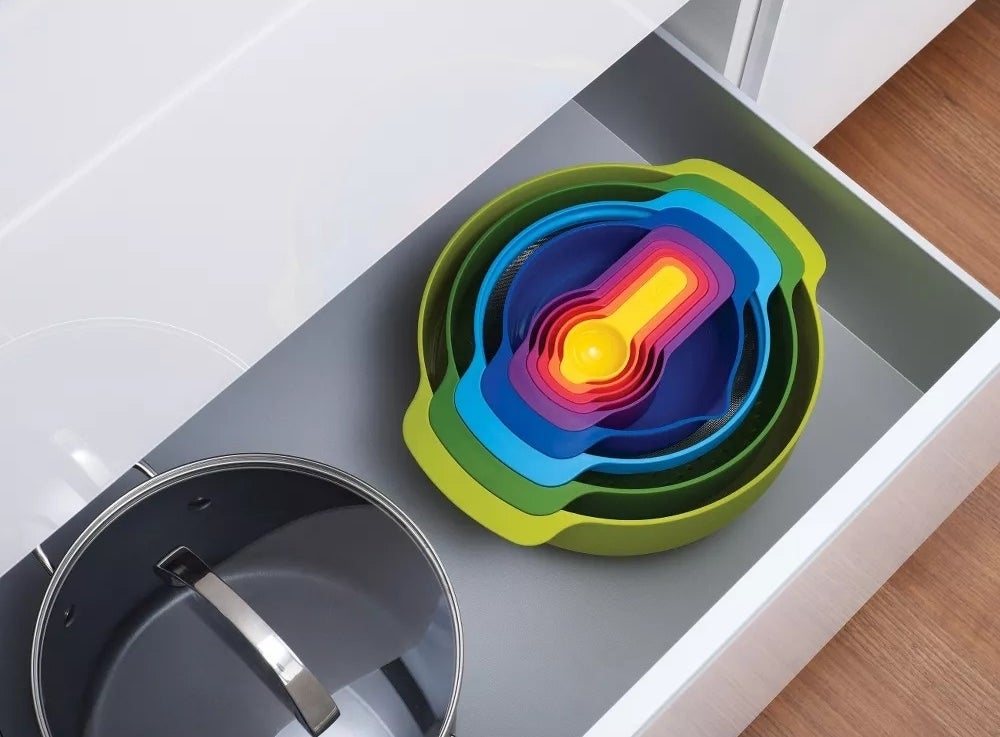 Colorful set of nesting bowls and measuring cups in a drawer