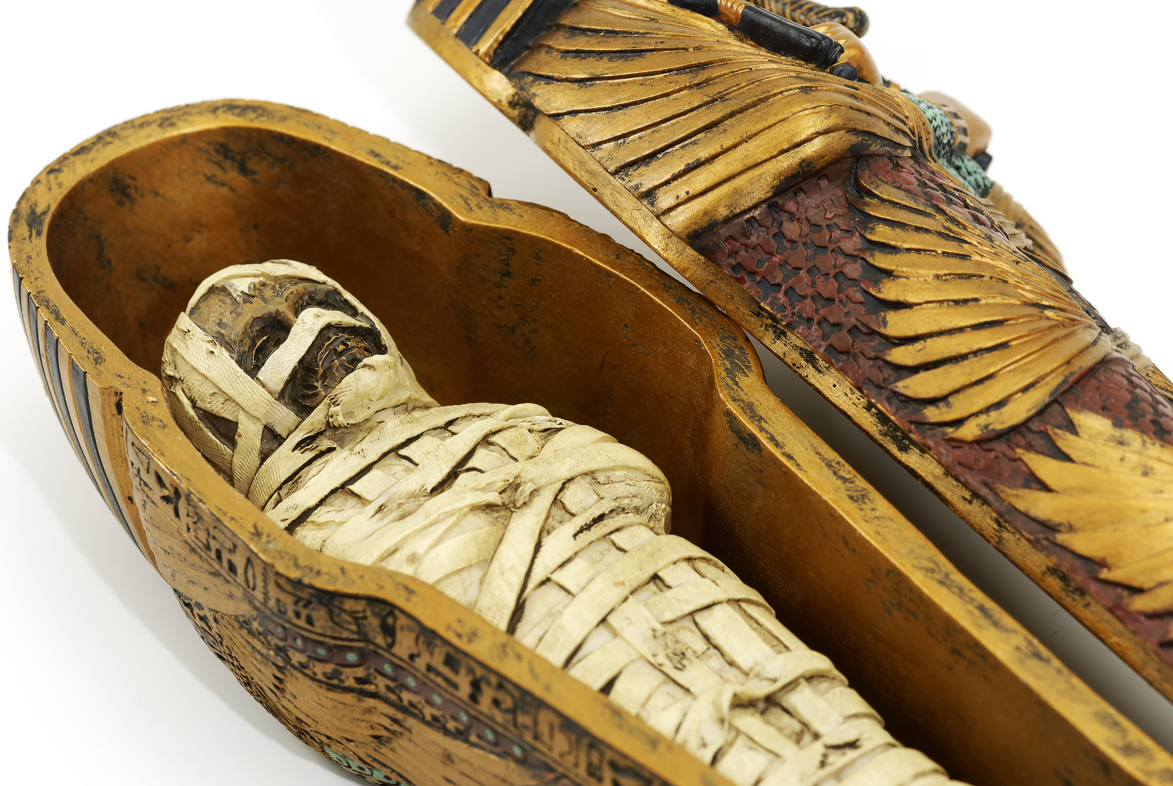 Two intricate Egyptian sarcophagi with a mummy inside one, symbolizing investment in historical artifacts