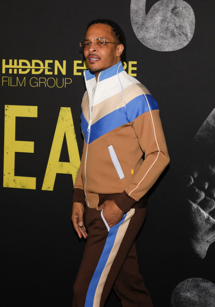 TI in a striped tracksuit stands on the event backdrop