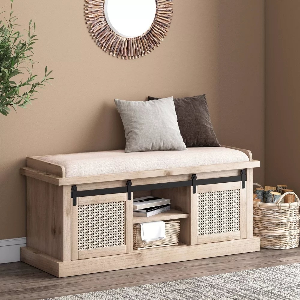 Wooden bench with cushion, storage baskets, and metal accents in an interior setting