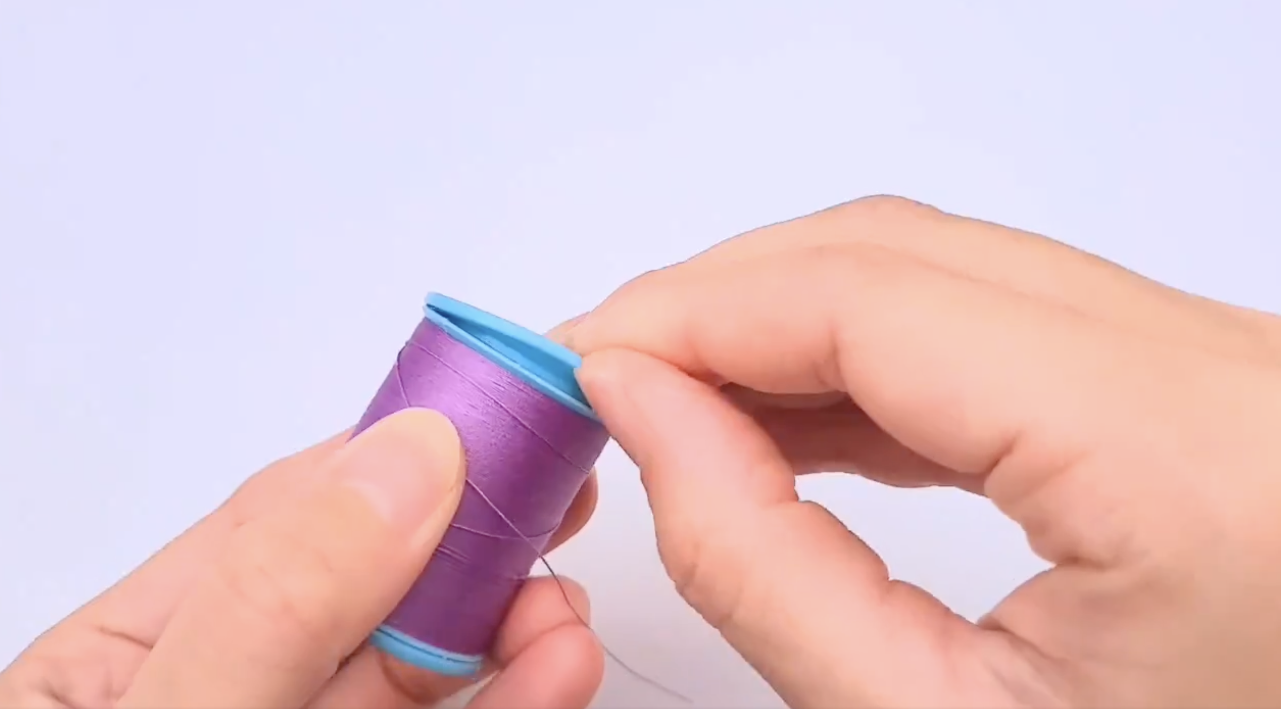 手が紫色のリボンの芯を開いている。