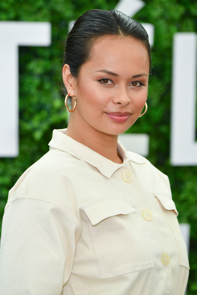 Woman in a chic short-sleeved top with button details poses for a photo