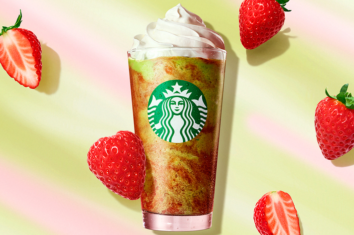 スターバックスのいちごフラペチーノ、周りに生のいちごが散らばっている。