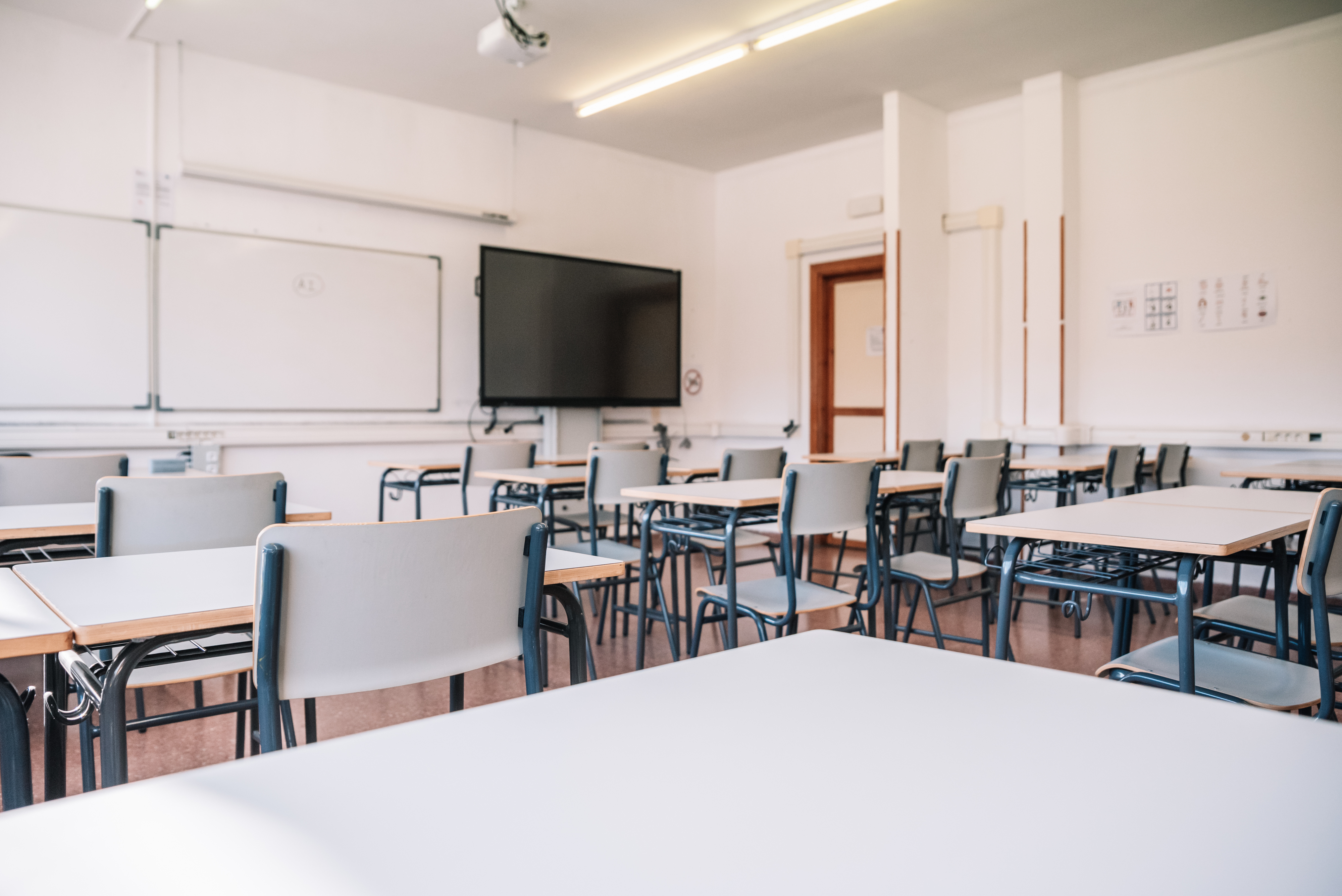 Empty classroom with desks, chairs, and a whiteboard