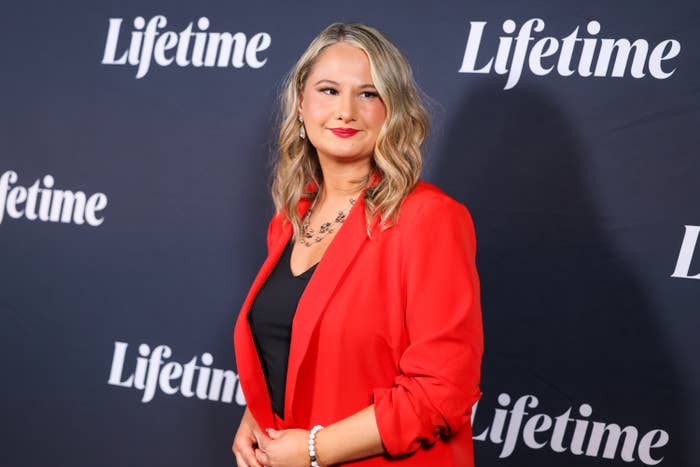 Gypsy Rose Blanchard in a red blazer posing on the Lifetime event backdrop