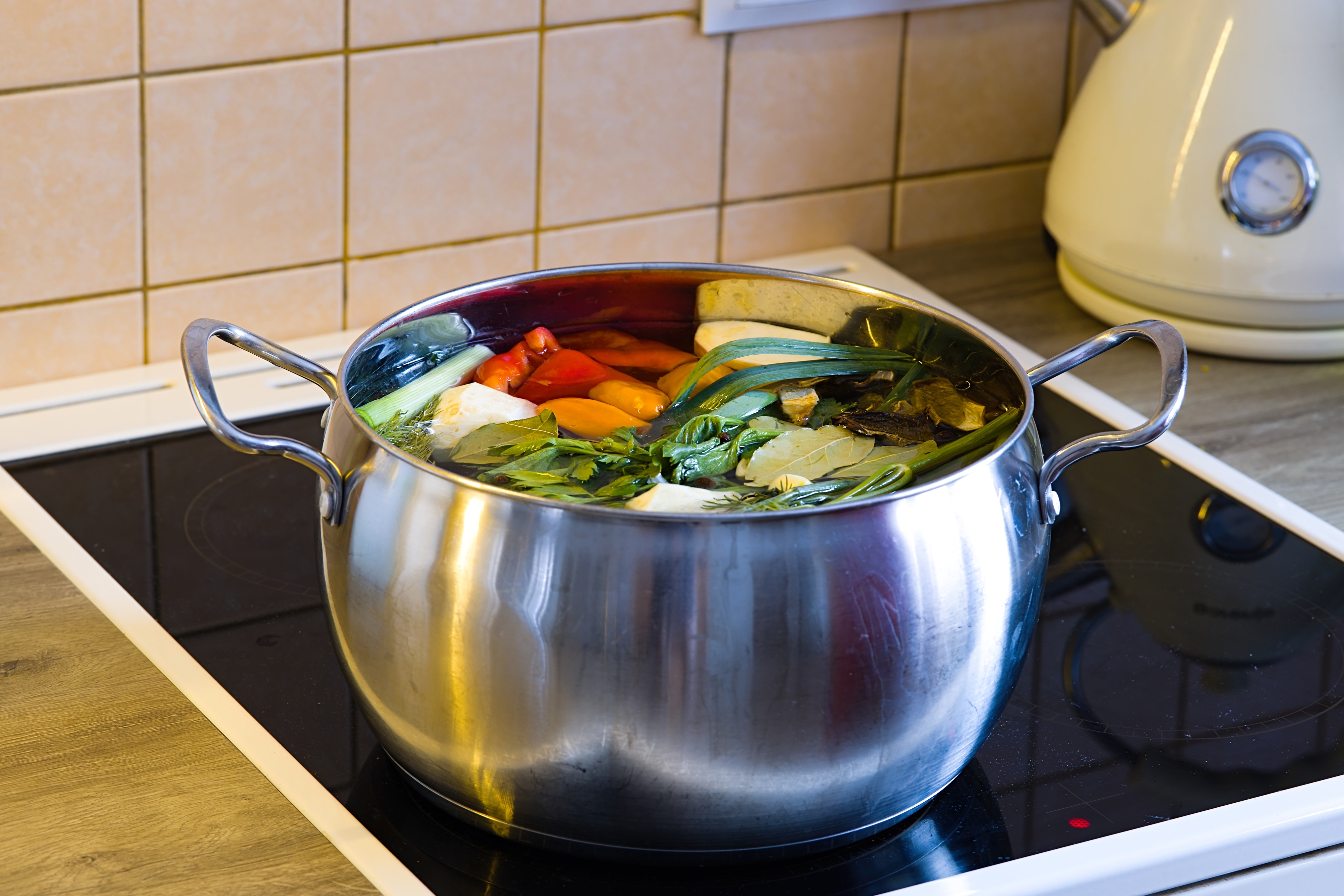 A pot of vegetables on a stove, ready for cooking