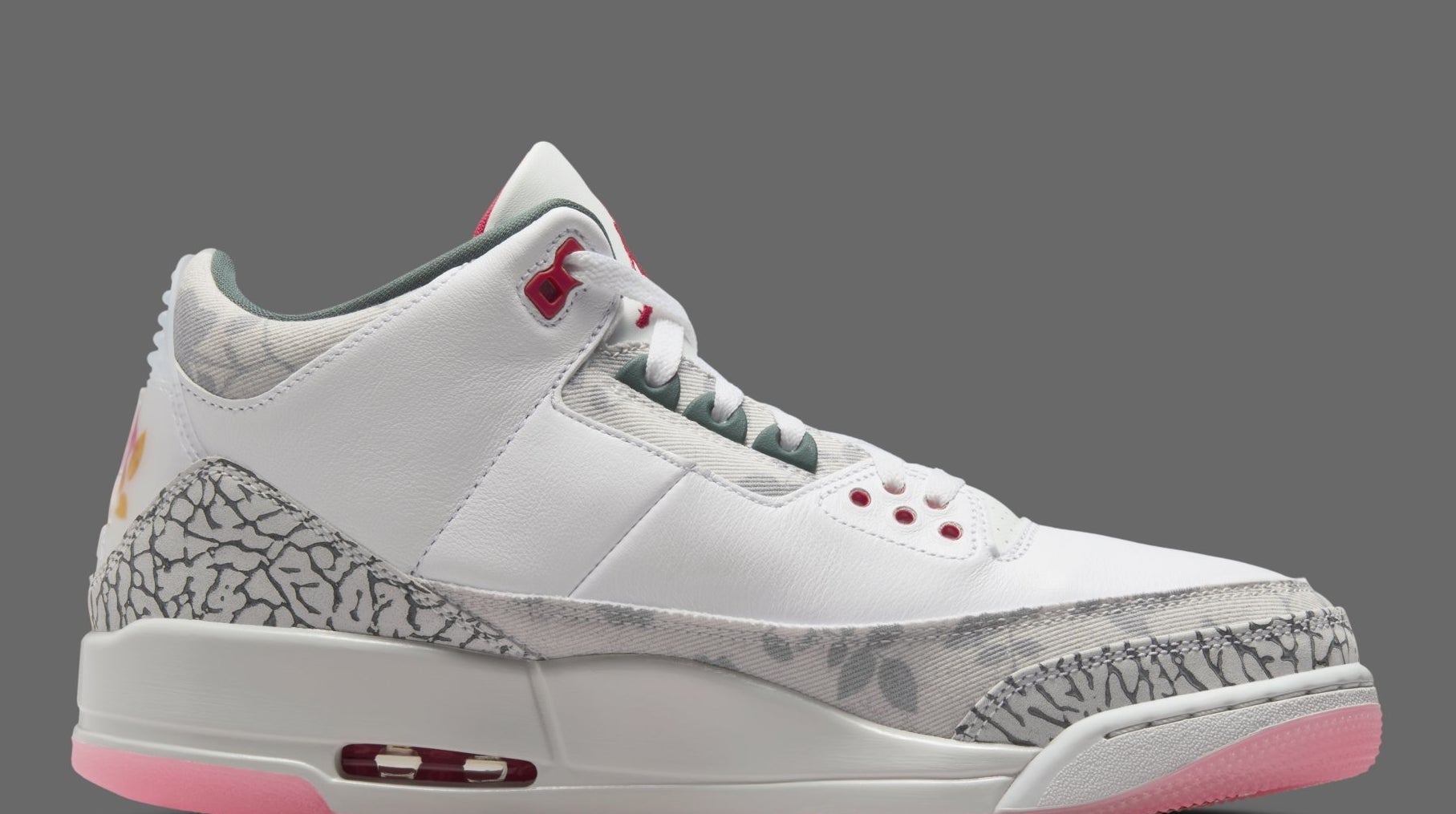 Side view of a white and grey Air Jordan 3 sneaker with red accents