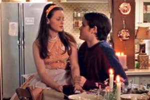Rory Gilmore and Dean Forester from Gilmore Girls sit closely at a candlelit dinner table